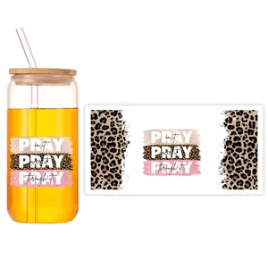 Dettaglio dell'adesivo UV DTF con stampa leopardata e testo PRAY su vetro da 16oz con tappo