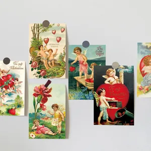 Detail of vintage Valentine cards with Cupid and floral motifs on white wall