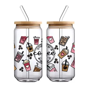Detail of UV DTF coffee decals applied on two glass cans with bamboo lids and glass straws
