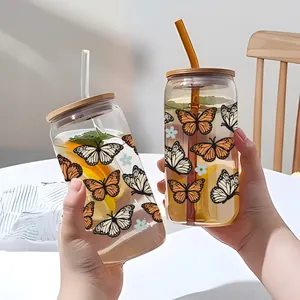 Dettaglio del bicchiere in vetro da 16oz con coperchio in bambù e adesivi UV DTF a farfalla
