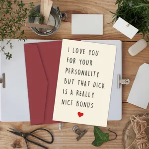 Divertente biglietto d'auguri con cuore rosso e busta su una scrivania in legno rustico