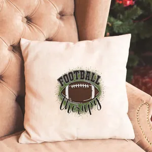 Détail de l'imprimé football therapy sur coussin en coton et lin sur un canapé marron
