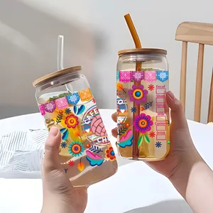 Détail d'un verre de 16oz avec transfert UV floral, couvercle en bambou et paille en verre