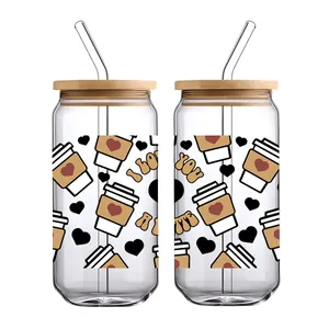 Detail view of 16oz glass cups with bamboo lids, glass straws, and cute coffee themed prints