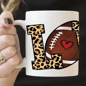 Detailopname van een witte keramische mok met luipaardprint L en voetbal hartpatroon