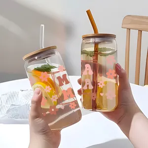 Close-up of two transparent 16oz glass cans with pink MAMA floral decals and bamboo lids