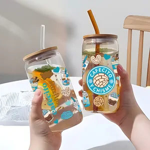 Detalle de vasos de 16oz con tapas de bambú y pegatinas UV de Cafecito y Chisme