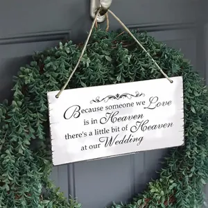 Close-up of wooden wedding sign with vintage script hung on a green eucalyptus wreath