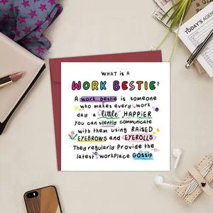 Close-up of Work Bestie funny greeting card with red envelope on a busy office desk