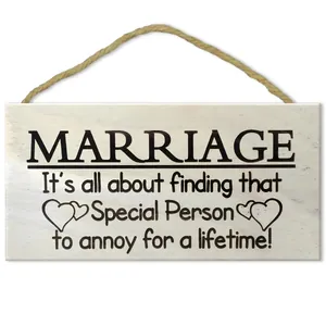 Detail of square wooden wall sign featuring humorous marriage quotes and jute rope