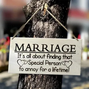 Detail of wooden wall hanging plaque with humorous marriage quote and rustic hemp rope