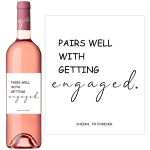 Detail of custom engagement wine bottle label with minimalist typography and floral neck wrap