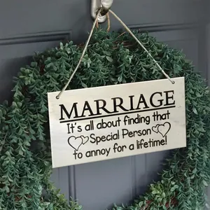 Close-up of square wooden kitchen sign with funny quotes hanging on a rustic wreath