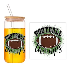Détail d'un autocollant UV DTF football sur verre de 16oz avec couvercle en bambou et paille