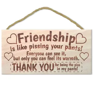 Close-up of wooden wall decor sign with heart pattern and funny kitchen quote