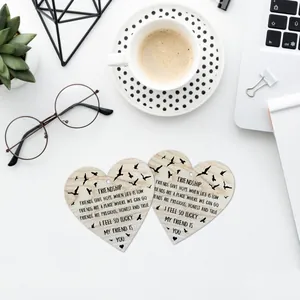 Close-up of heart-shaped wooden plaques featuring friendship verses and bird silhouettes