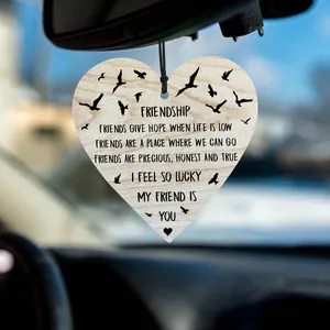 Detail of a heart-shaped wooden car pendant with friendship poem and black bird patterns