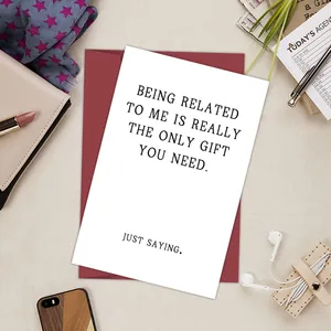 Flat lay of a funny birthday card with red envelope and modern lifestyle accessories