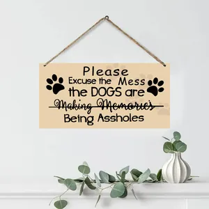 Detail of wooden sign with dog quotes hanging over fireplace with green plants