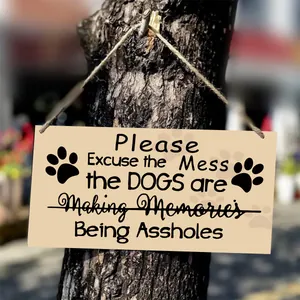 Detail of wooden sign with funny dog quote hanging from a rustic tree with rope
