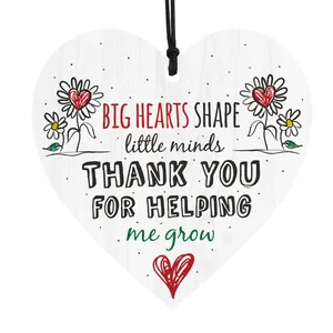 Detail of heart-shaped wooden plaque with floral patterns and gratitude quotes