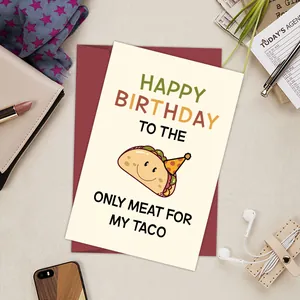 Close-up of funny Taco birthday card with red envelope on a cozy stationery background
