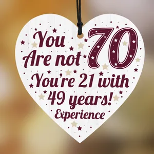 Detail of heart-shaped wooden 70th birthday plaque with humorous gold star print
