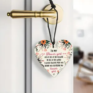 Detail of a heart-shaped wooden wedding sign for the flower girl with floral print