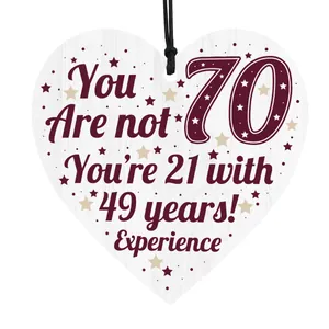 Detail of 70th birthday heart-shaped wooden plaque with humorous quote and rustic stars