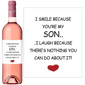 Detail shot of customized wine bottle labels with artistic text and red heart designs