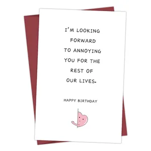 Funny birthday card with burgundy envelope and pink heart illustration set on plain background