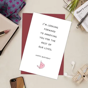 Funny birthday card with red envelope on a lifestyle desk setup with stylish props