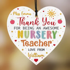 Close-up of heart-shaped wooden teacher gift with red apple and thank you message