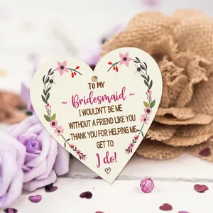 Macro detail of heart-shaped wooden bridesmaid thank you tag with pink floral wreath design