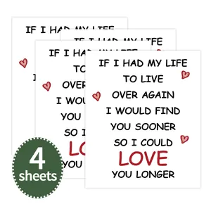 Macro detail of 4 white decorative wine bottle labels with romantic quotes and red hearts
