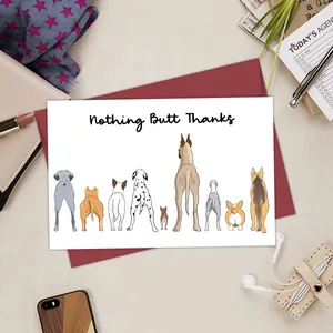 Detail view of funny corgi butt greeting card with matching dark red envelope on a desk