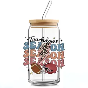Detail van de UV DTF cup wrap met voetbalprint op een 16oz glazen beker met rietje
