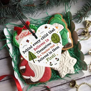 Close-up of heart-shaped wooden teacher gift plaque in festive holiday gift box