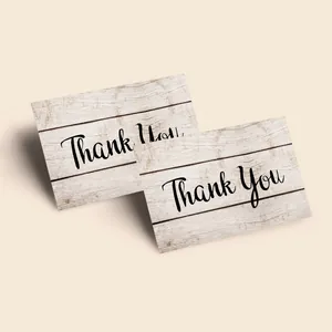 Macro detail of paper thank you cards with vintage wood grain texture and elegant script
