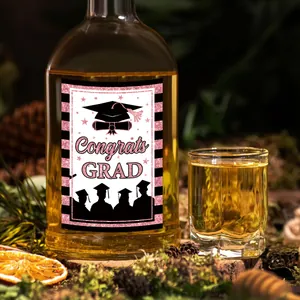 Dettaglio dell'etichetta Congrats Grad per bottiglia con strisce nere e rosa in natura