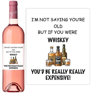 Macro view of funny wine bottle labels with humorous quotes and whiskey illustrations