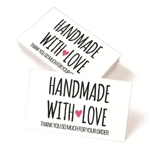 Detail view of handmade labels with pink heart and thank you message on white cards