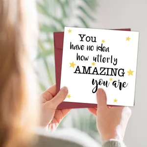 Close-up of white square greeting card with yellow stars and a burgundy envelope
