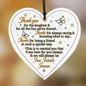 Detail of wooden heart plaque with friendship quote, butterfly and floral patterns