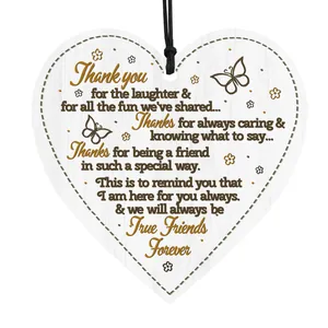 Detailed view of heart-shaped wooden plaque with butterfly patterns and friendship message