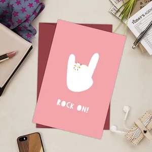 Flat lay of pink Rock On birthday card with diamond ring graphic and red envelope