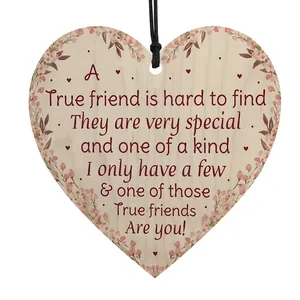 Detail of heart-shaped wooden friendship plaque with floral patterns and printed quote