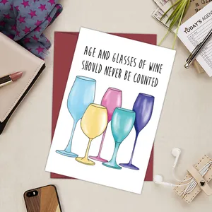 Flat lay of a funny birthday card with wine glass illustrations and a red envelope