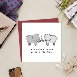 Funny anniversary greeting card with cartoon elephants and a deep red envelope