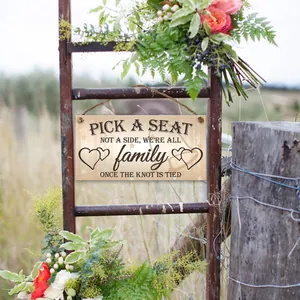Rustic wooden wedding sign with hemp rope hanging on a vintage metal ladder with flowers